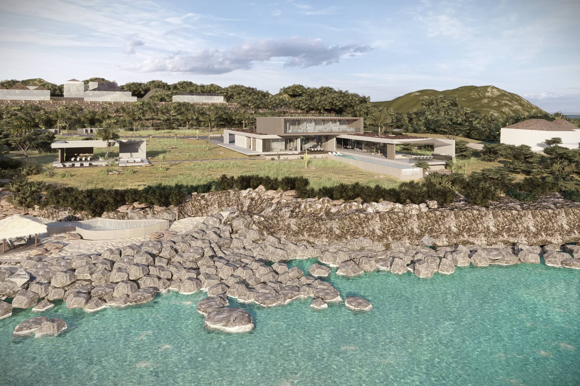 Villa aan zee met natuurstenen rotswand, tropisch groen en helderblauw water.