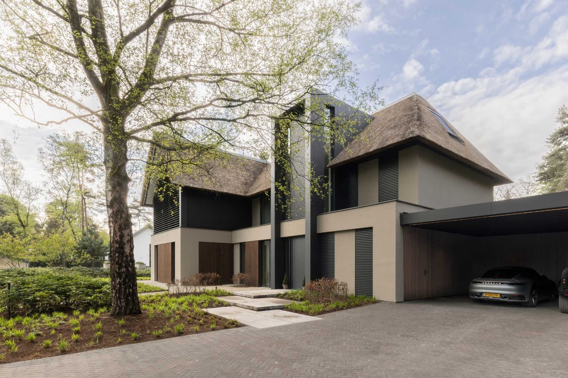 bosvilla waalre in de bossen vanuit de voorkant met garage, gemaakt van beton voortuin en pad